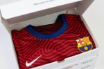 Coffret Un Bon Maillot ouvert révélant un maillot du FC Barcelone, prêt à ravir les fans de football.