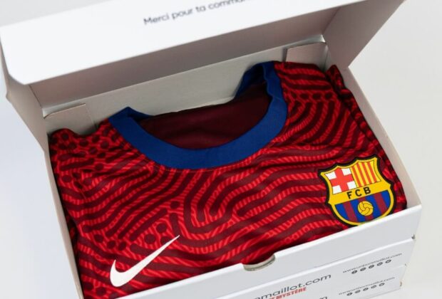 Coffret Un Bon Maillot ouvert révélant un maillot du FC Barcelone, prêt à ravir les fans de football.