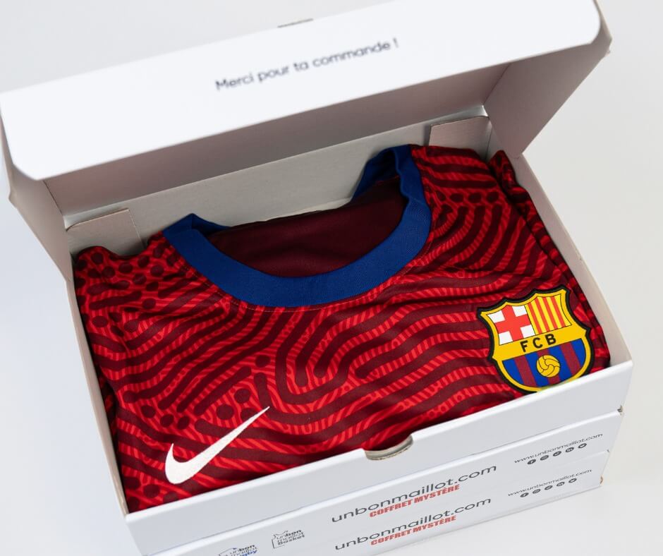 Coffret Un Bon Maillot ouvert révélant un maillot du FC Barcelone, prêt à ravir les fans de football.