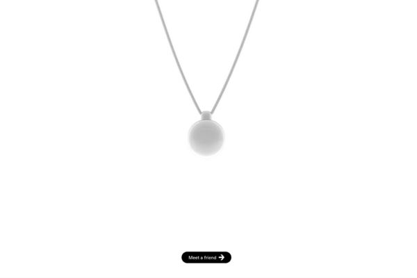 Pendentif connecté Friend AI de couleur blanche avec cordon, design circulaire minimaliste.